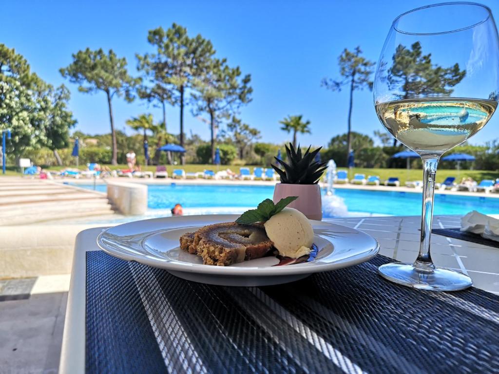 a plate of food and a glass of wine on a table at Victory Village 18E in Quinta do Lago