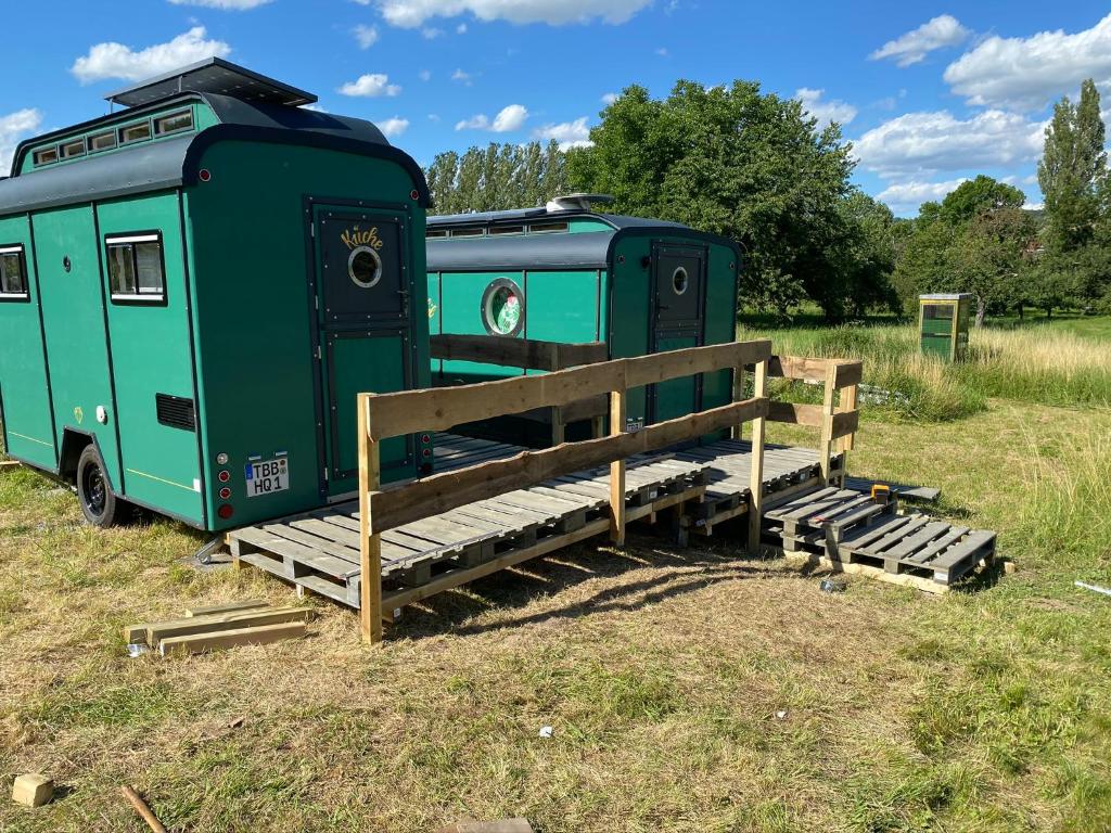 ein paar grüne Anhänger auf einem Feld geparkt in der Unterkunft Tauber Glamping Mobil in Tauberbischofsheim