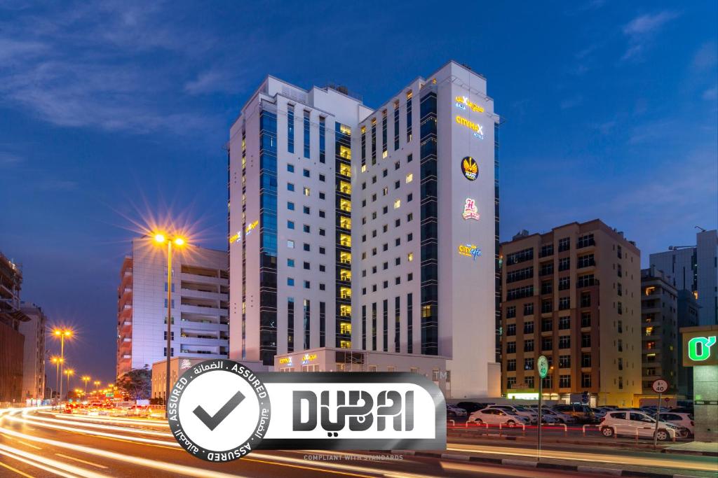 Citymax Hotel Al Barsha at the Mall في دبي: مبنى طويل مع علامة أمامه