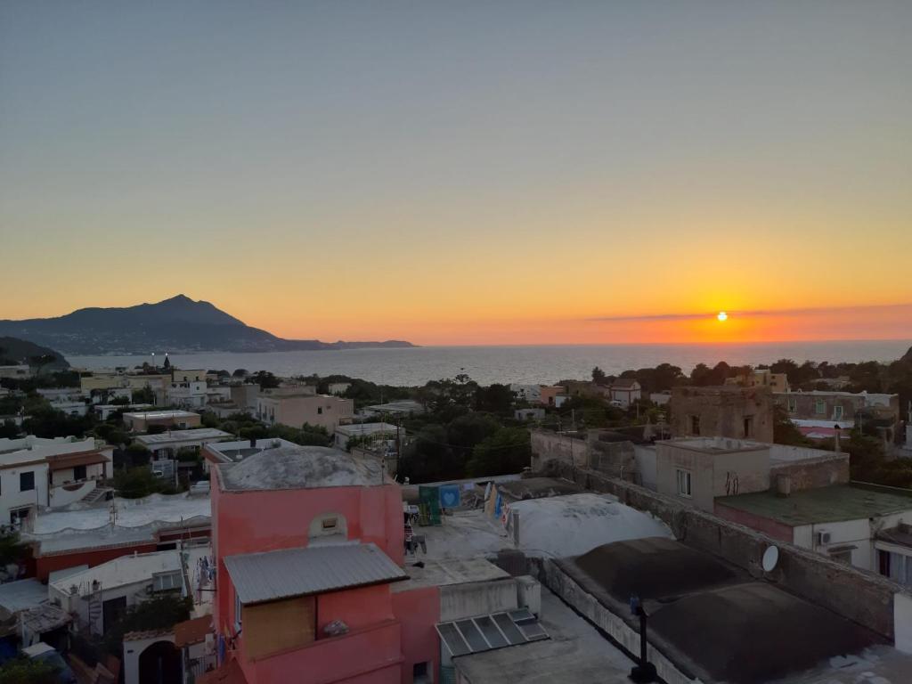 a view of a city with the sunset in the background at Le Volte Procida Home in Procida