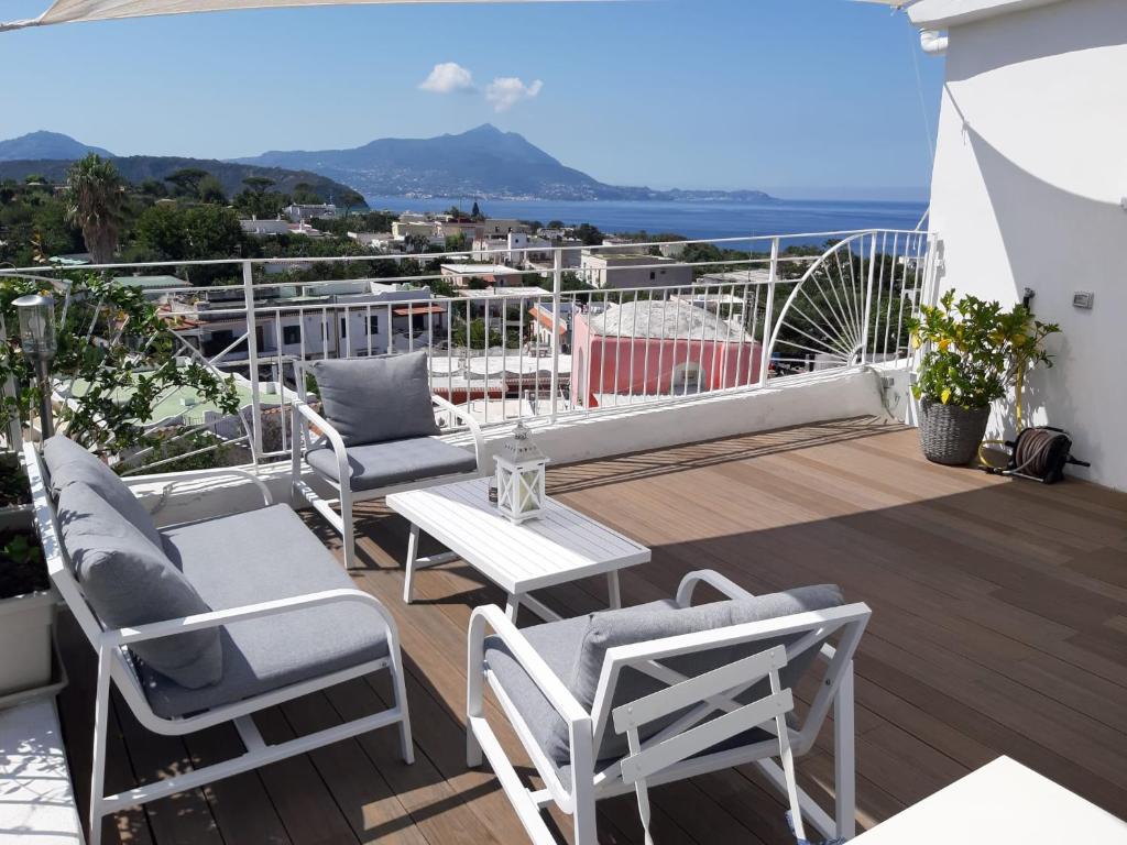 a balcony with chairs and a table and a view of the ocean at Le Volte Procida Home in Procida