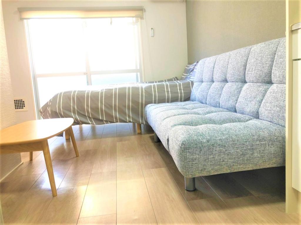 una sala de estar con un sofá y una mesa en Hotel Peace Park Tokaichi, en Hiroshima