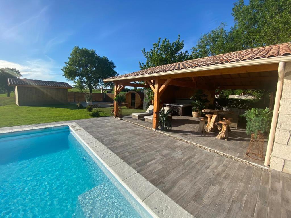 un pavillon et une piscine dans une cour dans l'établissement Le Refuge des Épicuriens, à Eymet