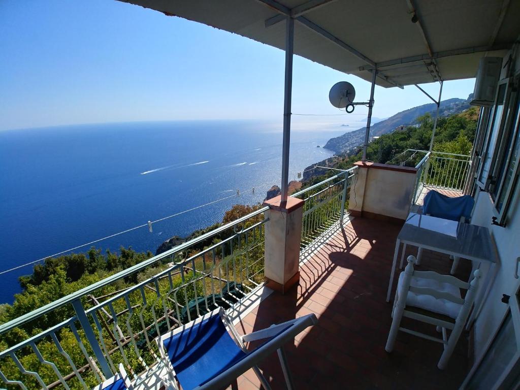 a balcony with chairs and a view of the ocean at GIARDINO SUL MARE in Amalfi