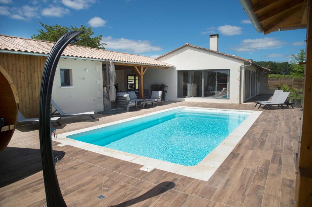 a swimming pool in a backyard with a house at Aux Escapades de Monbazillac in Monbazillac
