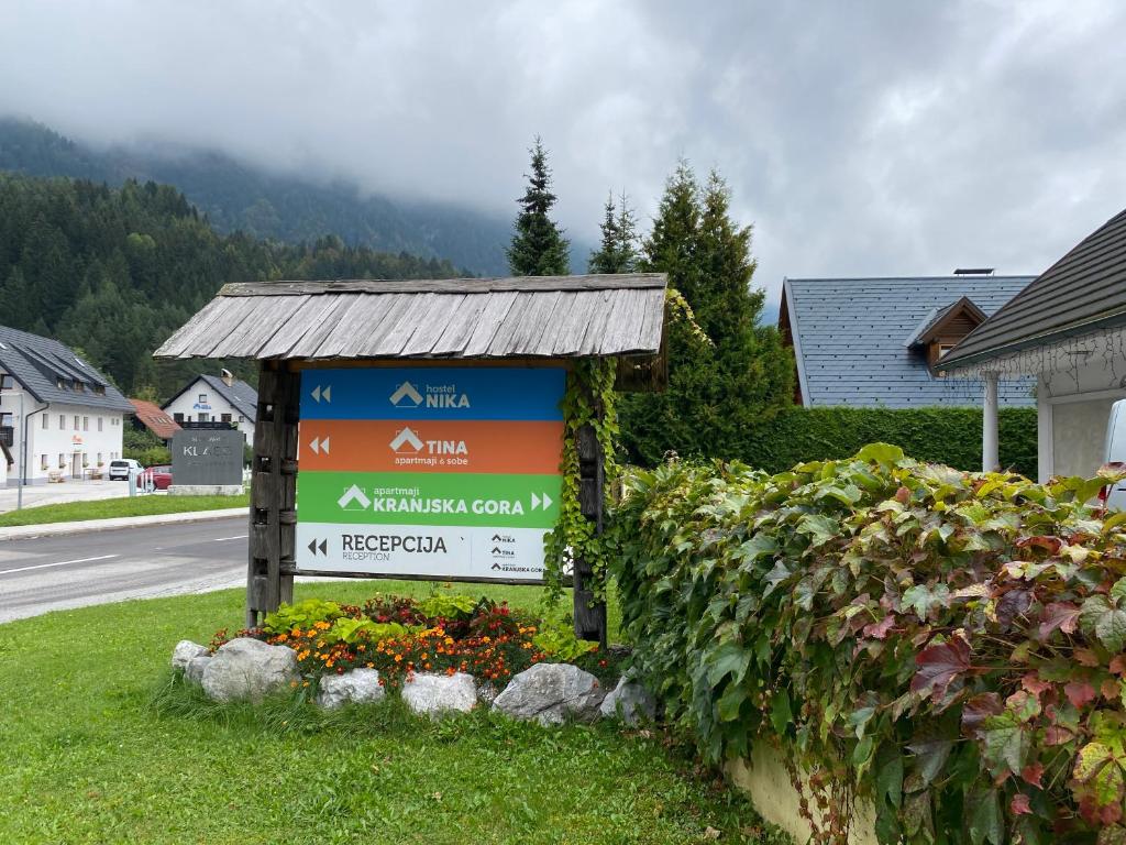 a sign in the grass next to a house at Apartmaji Kranjska Gora in Kranjska Gora