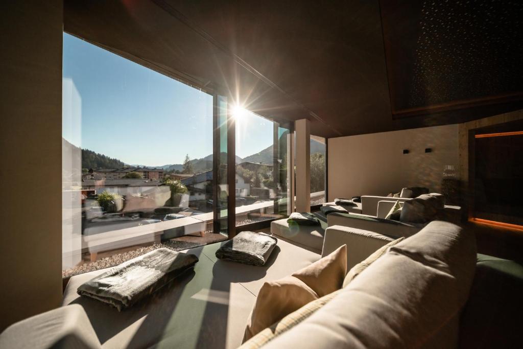 a living room with couches and a large window at Der Postwirt in Söll