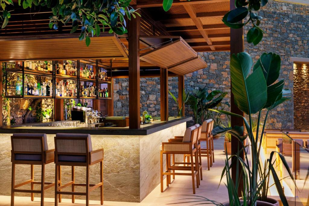 a bar in a restaurant with chairs and tables at Daios Cove in Agios Nikolaos