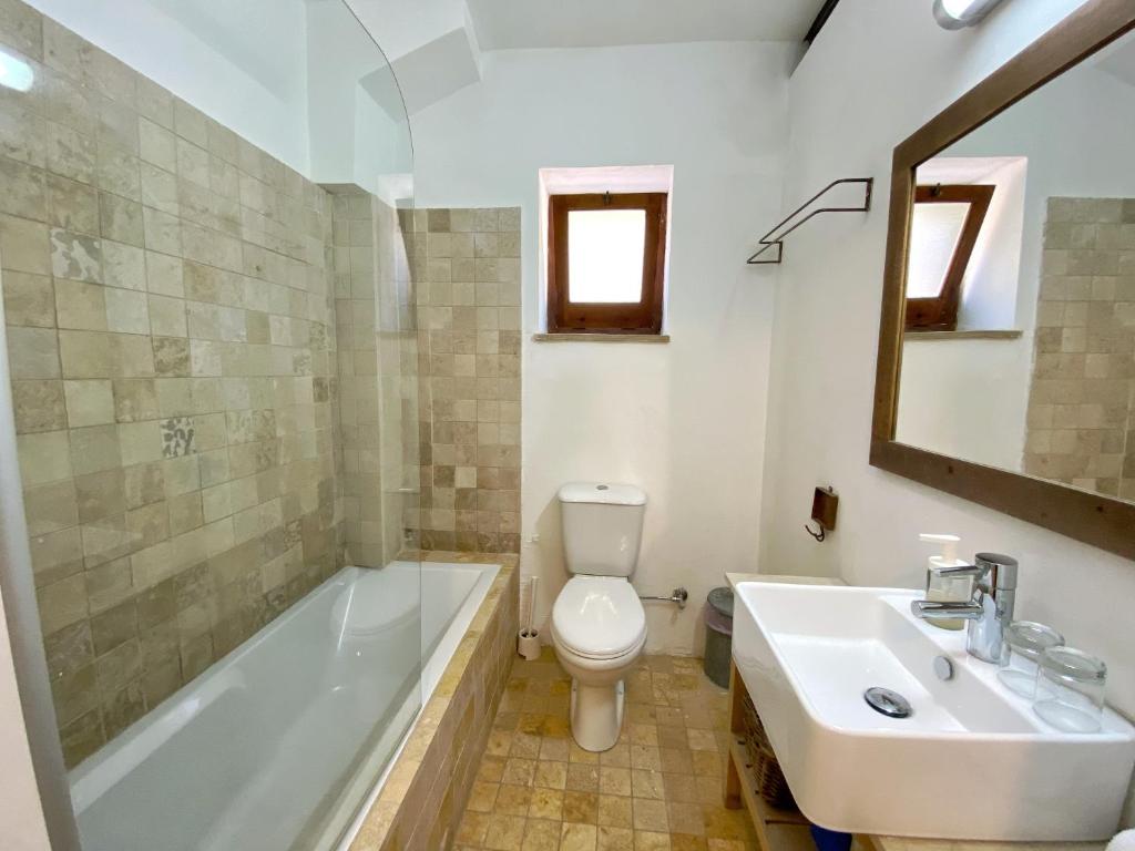 a bathroom with a tub and a toilet and a sink at Eveleos Country House in Tochni