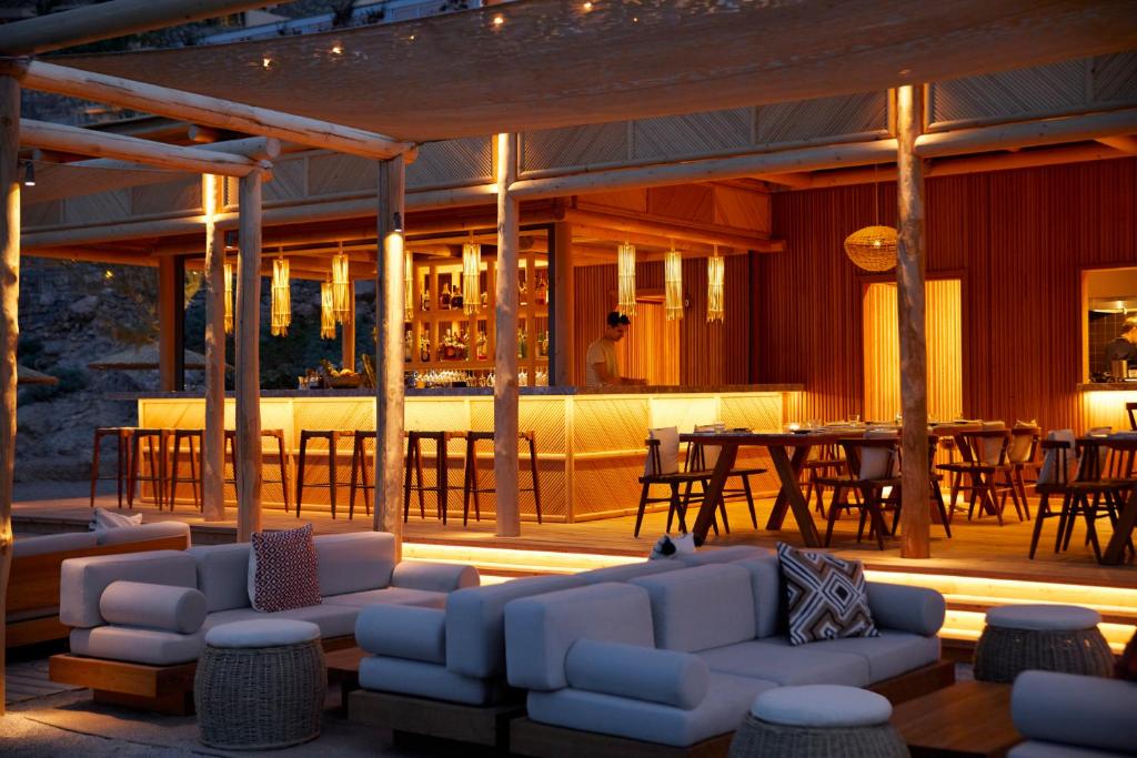 a patio with white couches and a table and chairs at Daios Cove in Agios Nikolaos