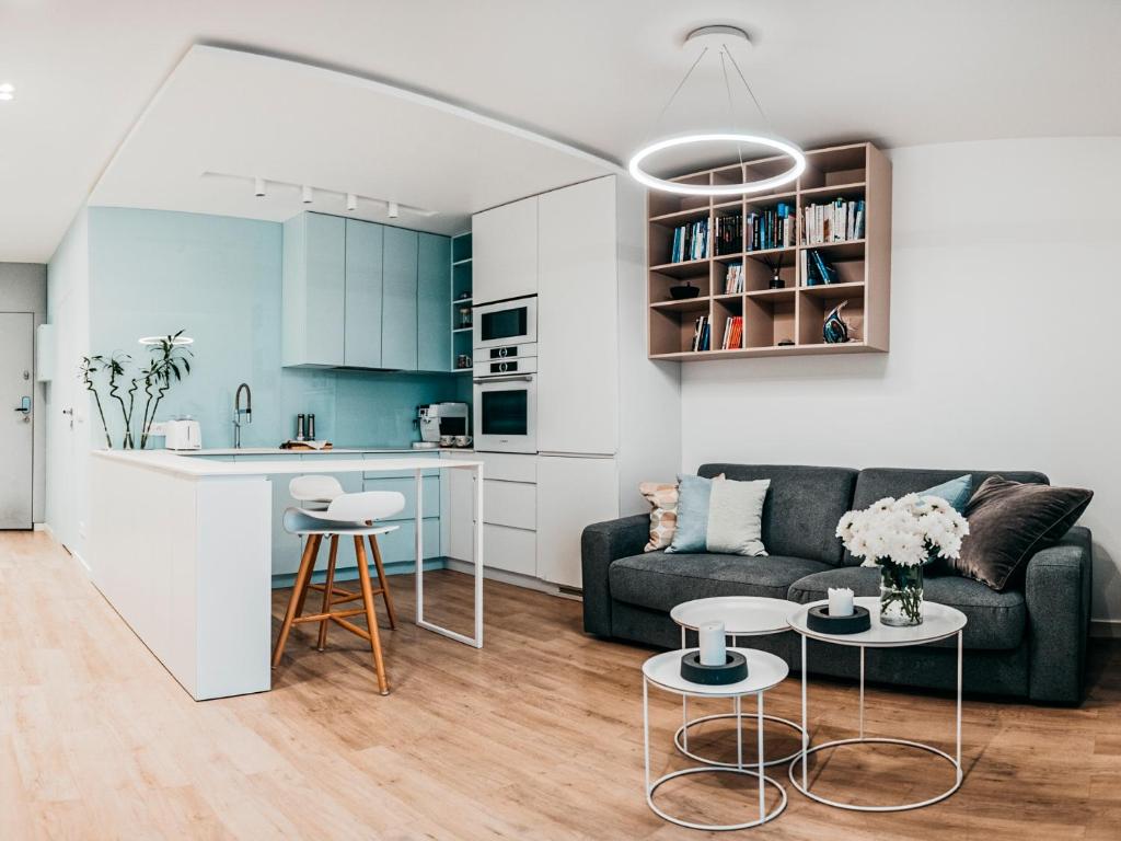 a living room with a couch and a kitchen at Oceana Silesian Place Apartments in Katowice