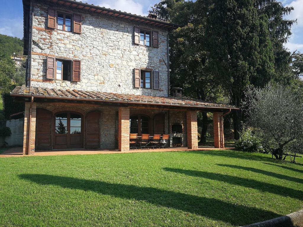 una antigua casa de piedra con un gran patio de césped en casa marconi, en Vetriano