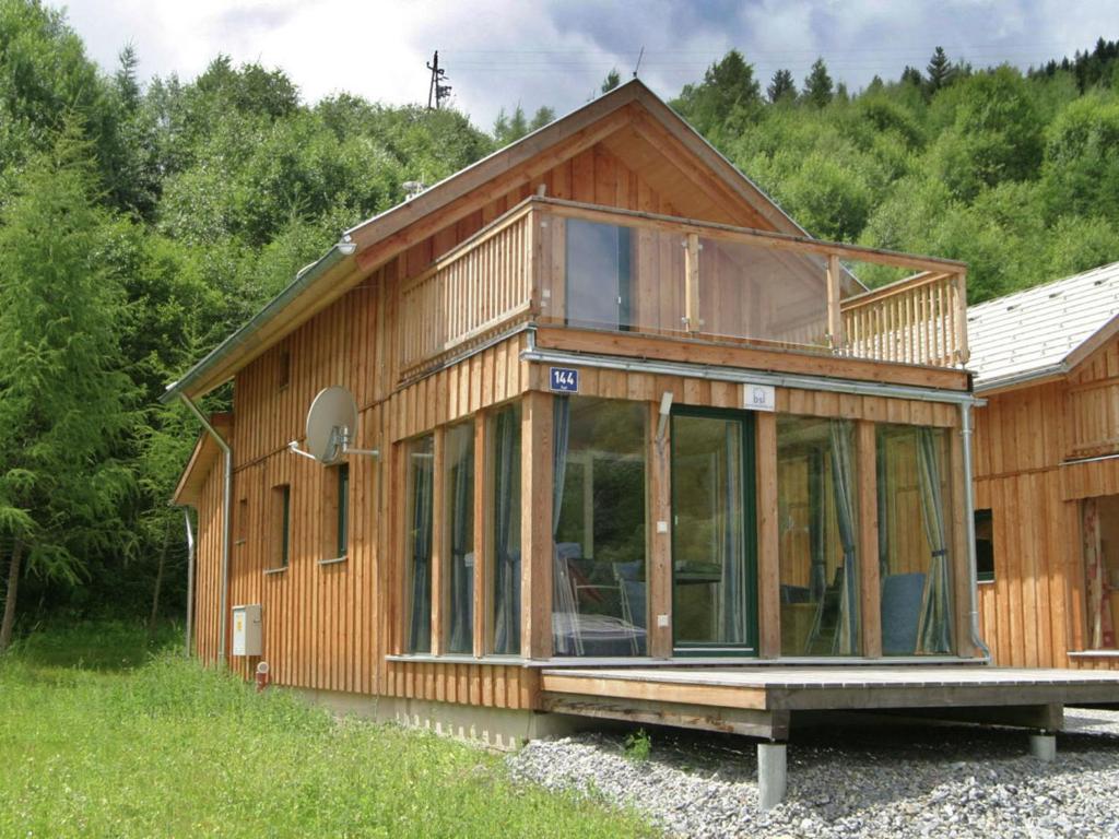 una casa in legno con finestre in vetro su una collina di Chalet in Stadl an der Mur Styria with sauna a Stadl an der Mur