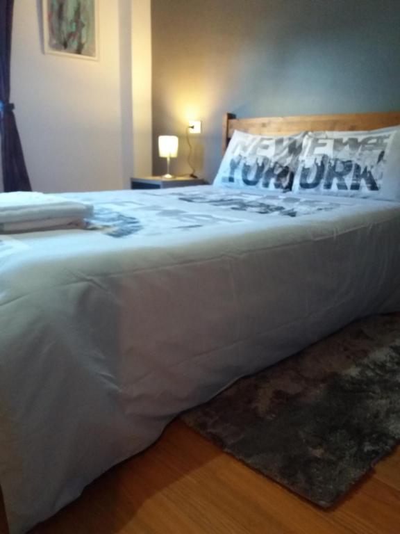 a large white bed with a pillow on it at near airport in Las Lagunas