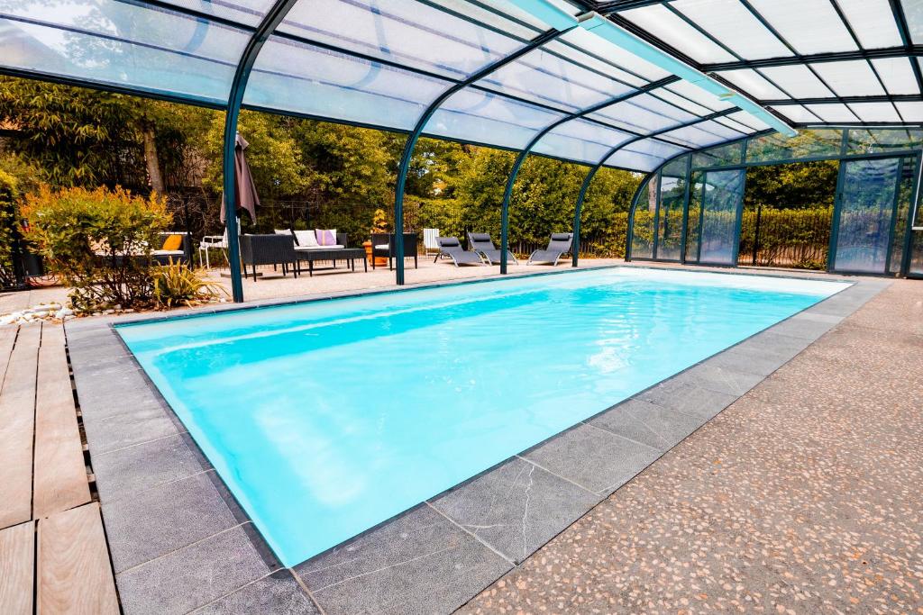 an indoor swimming pool with a glass roof at Hôtel Villa Flornoy Pornichet Baie de la Baule in Pornichet