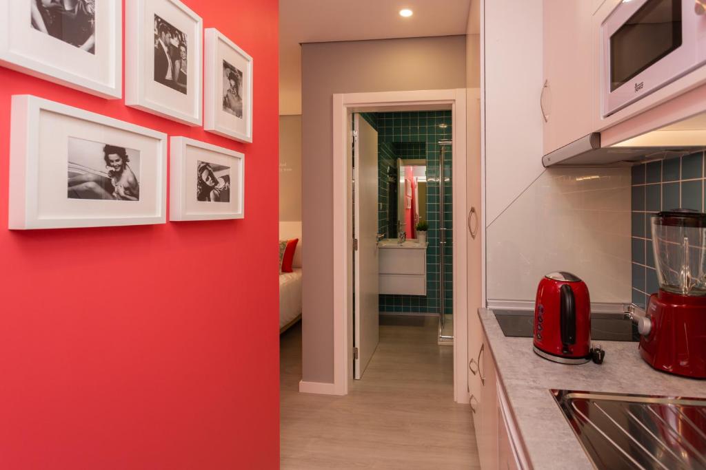 a kitchen with red walls and a red wall at Chic Studios in Parede