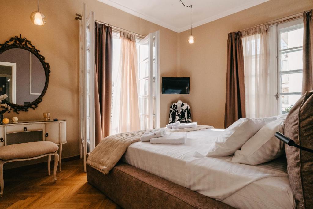 um quarto com uma cama grande e um espelho em Deluxe residence uncle Vassos em Tessalônica