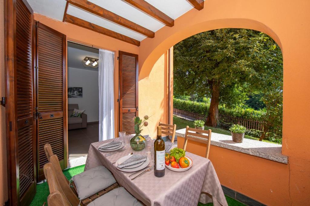 einen Tisch mit einer Schale Obst und einer Flasche Wein in der Unterkunft Menaggio Palphi in Menaggio