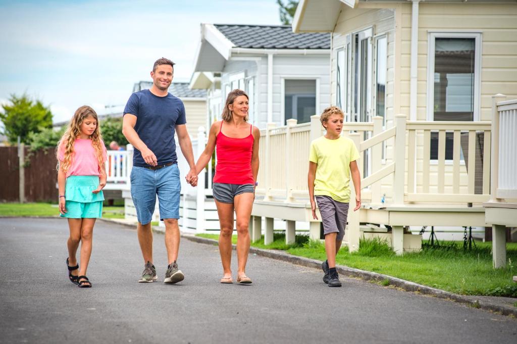 バーナム・オン・シーにあるSandy Glade Holiday Parkの家の前の通りを歩く家