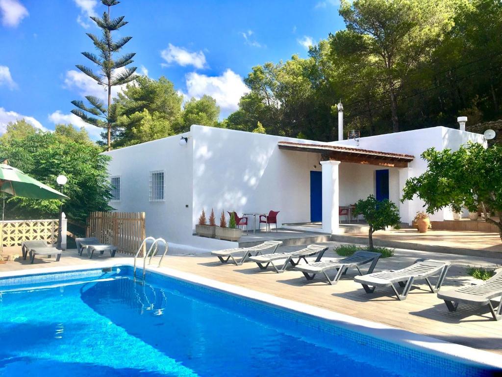 a villa with a swimming pool and a house at Villa Alexa this charming villa is just a 10 min drive to either Playa Den Bossa or San Antonio in Sant Josep de sa Talaia