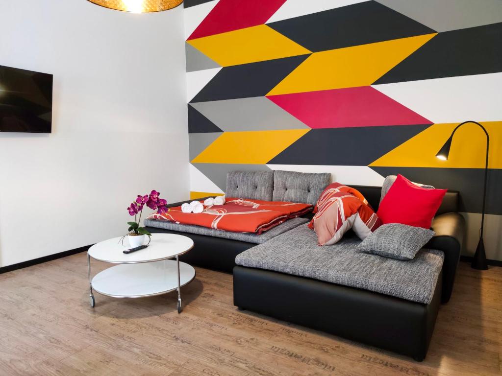 un soggiorno con divano e parete colorata di Highlight Apartment Naschmarkt a Vienna