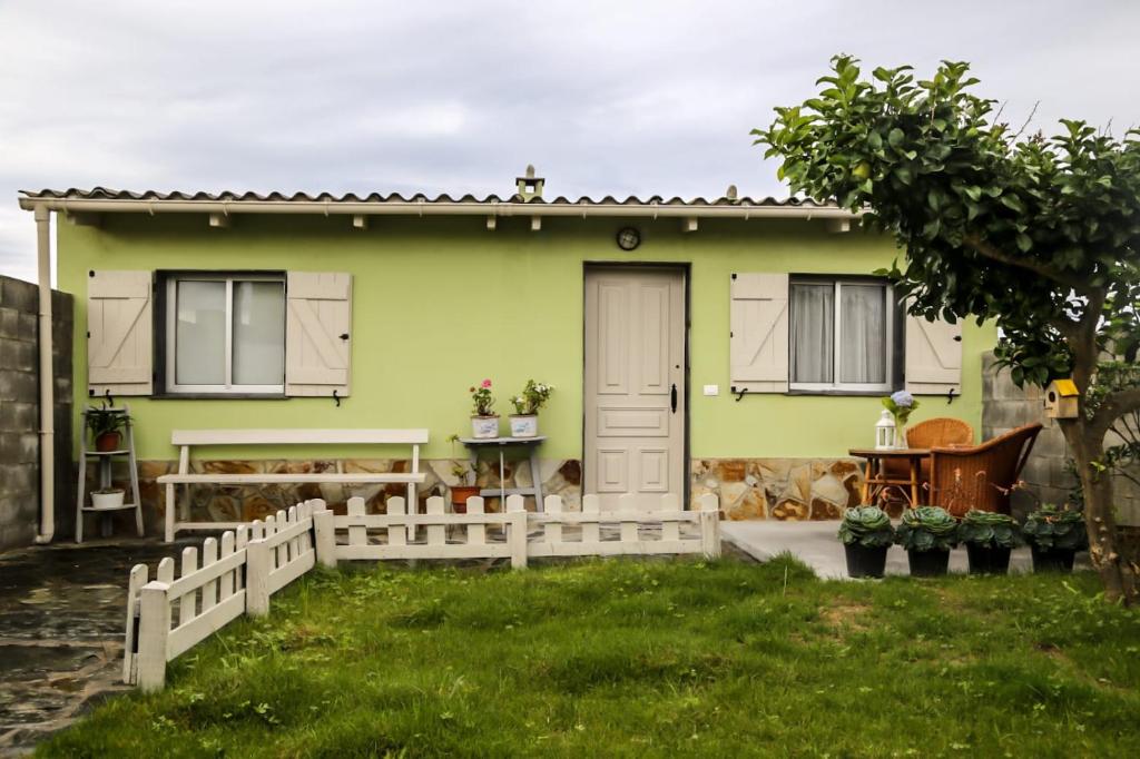 een groen huis met een hek ervoor bij Casa de arriba in Rinlo