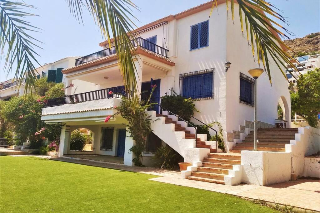 Casa blanca con escaleras y césped verde en Auténtica Casa Mediterránea con vistas al mar, en Santa Pola