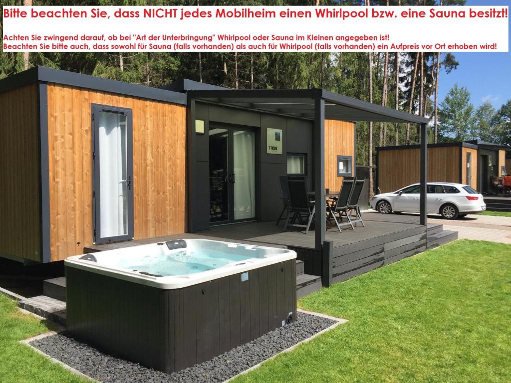 a small house with a hot tub in the yard at WA100 - Moderne Mobilheime im Oberpfälzer Seenland in Wackersdorf