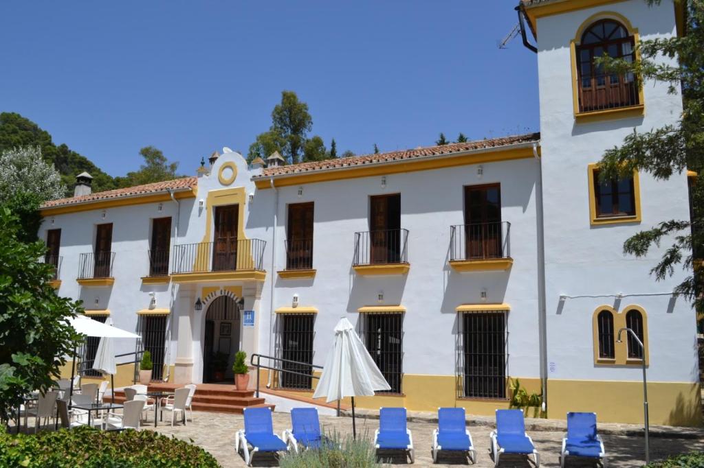 um grande edifício branco com cadeiras azuis em frente em Hotel Humaina em Málaga