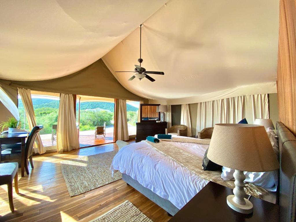 1 dormitorio con 1 cama y ventilador de techo en ParkView Safari Lodge en Colchester