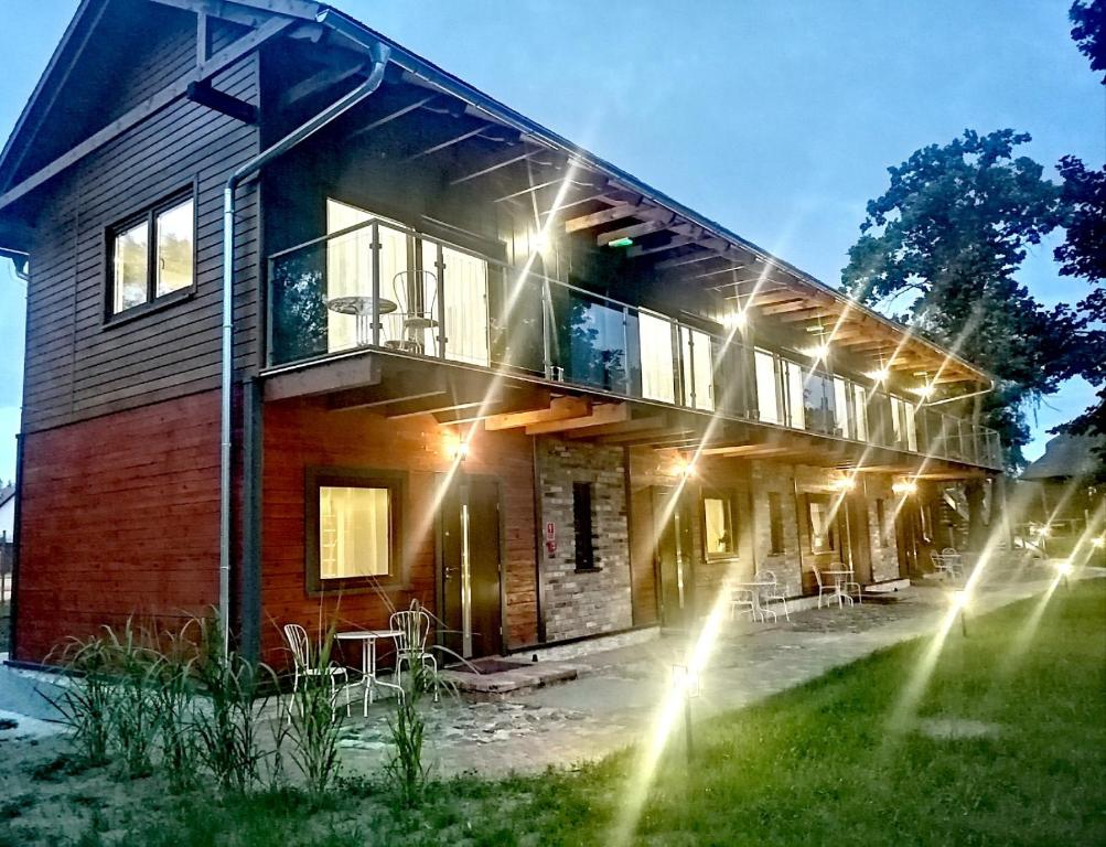 une maison avec des lumières sur le côté dans l'établissement Cztery Sosny - noclegi Zasieki, à Zasieki