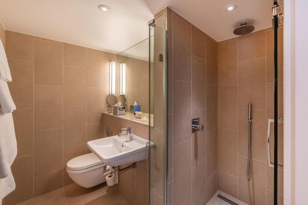 a bathroom with a toilet and a sink and a shower at The Resident Victoria in London