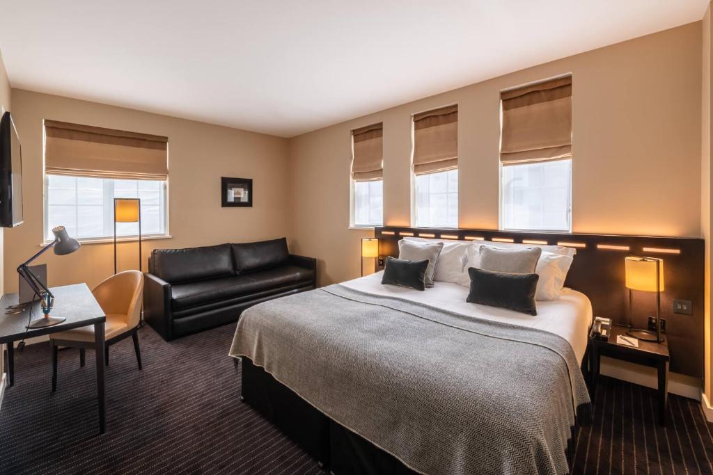 a hotel room with a bed and a chair at The Resident Victoria in London