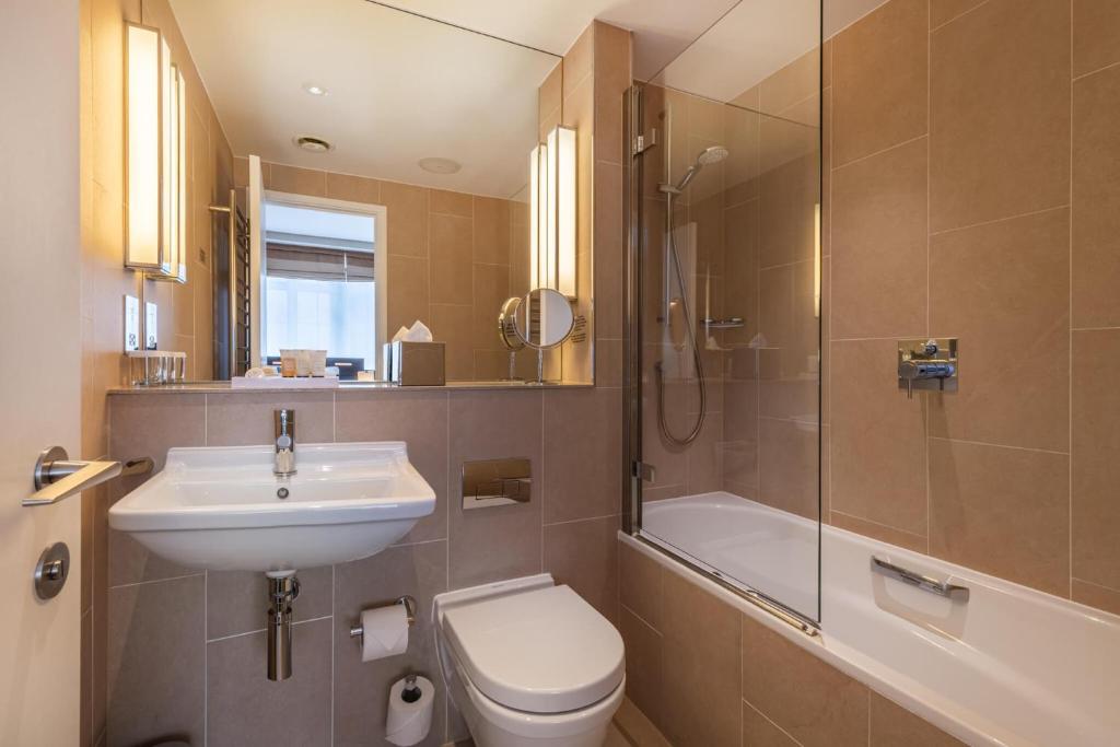 a bathroom with a toilet and a sink and a shower at The Resident Victoria in London