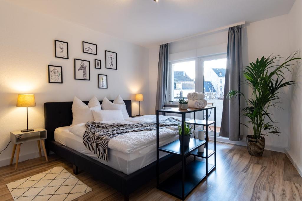 a bedroom with a bed and a window with plants at E&K City Apartments in Wuppertal