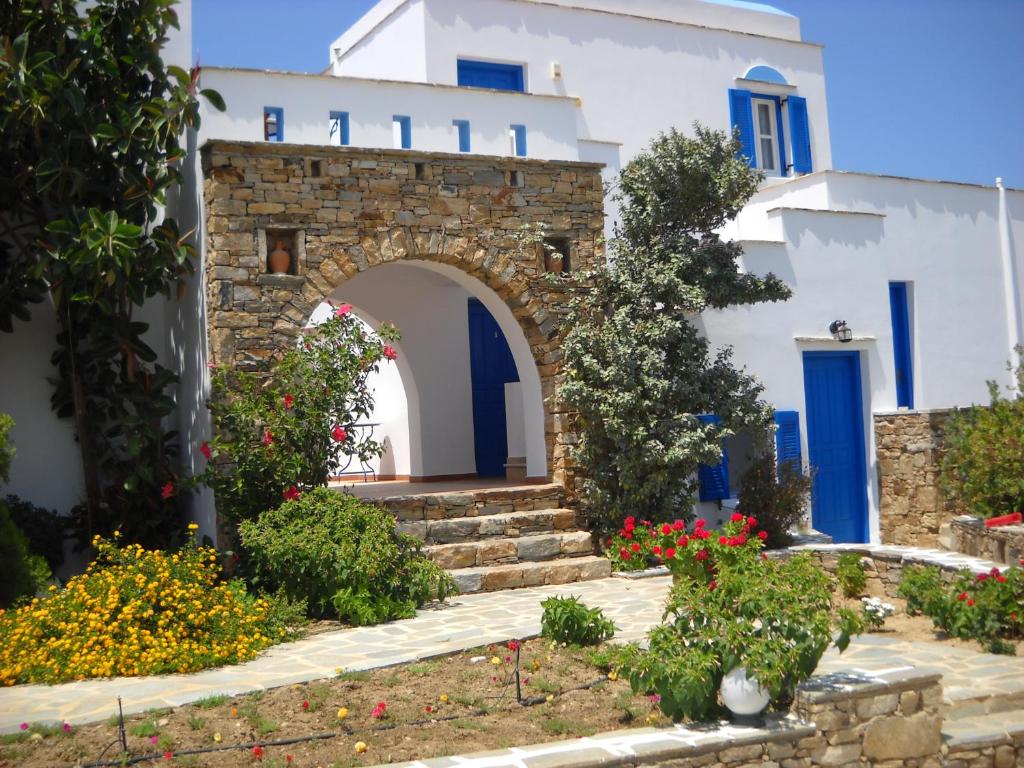 ein Gebäude mit blauen Türen und Blumen im Hof in der Unterkunft Mateus Studios in Plaka