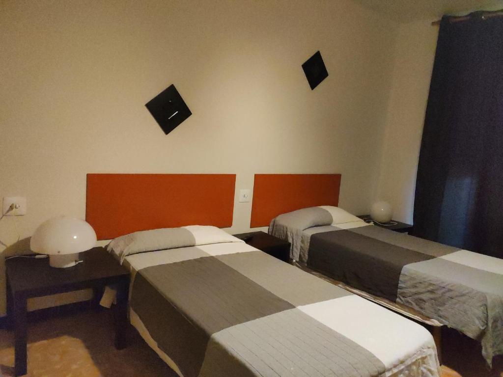 - 2 lits dans une chambre avec des miroirs sur le mur dans l'établissement Fonda Ca La Maria, à Avinyó