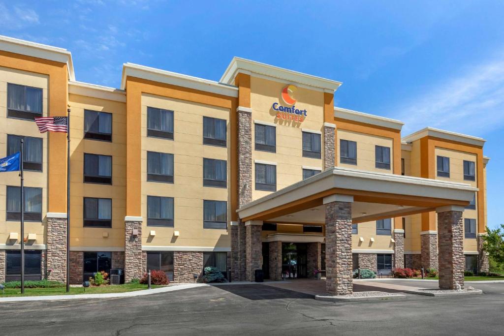 an exterior view of a hotel with an american flag at Comfort Suites in Oshkosh