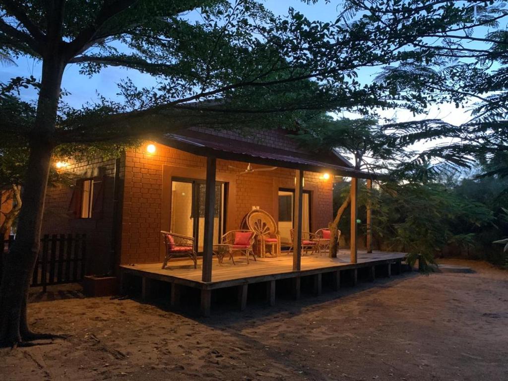 a small house with a porch and a patio at Natura luxury red house in Ouidah