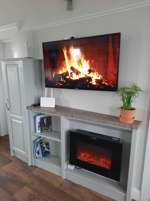 a fireplace with a tv on top of it at River Shack in Doolin