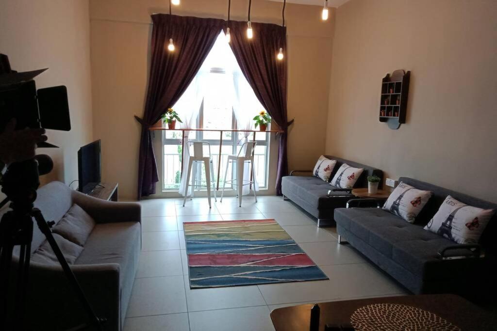 a living room with couches and a large window at LOVE LODGE BRINCHANG, CAMERON HIGHLANDS in Tanah Rata