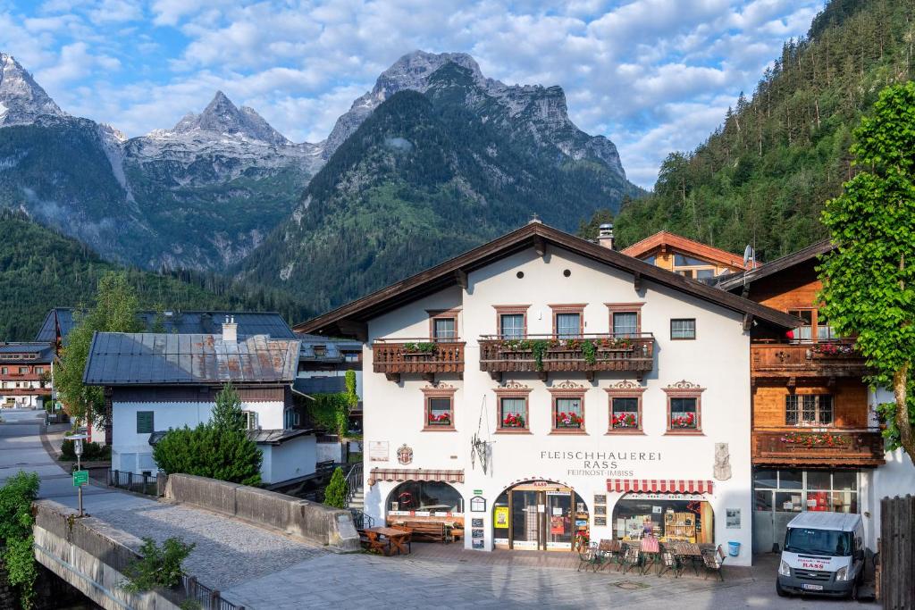 a building in a town with mountains in the background at Gästehaus Rass in Lofer