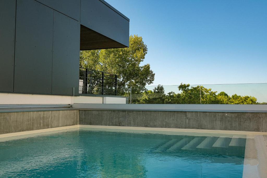 a swimming pool in front of a house at Live Hotels Bordeaux Lac in Bordeaux
