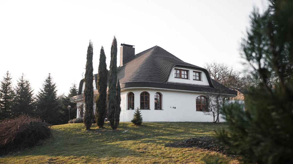 a white house with a black roof and some trees at Ubytování Pod lázněmi Klimkovice in Klimkovice