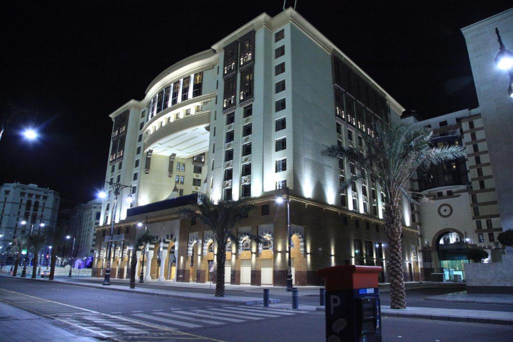 a large building on a city street at night at Rua Al Hijrah Hotel in Al Madinah