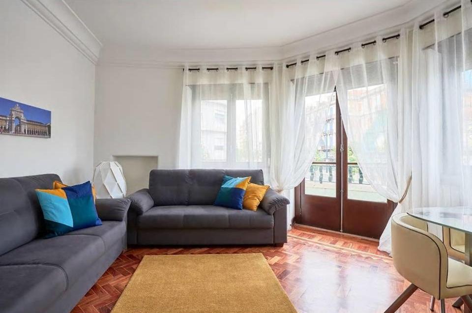 uma sala de estar com um sofá e uma mesa em Green Corner House em Lisboa