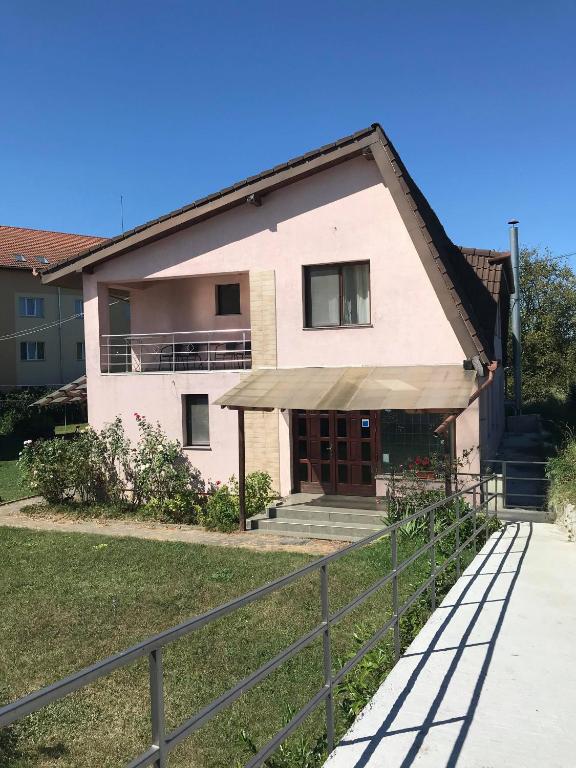 a house with a fence in front of it at Silviu in Baile Unu Mai
