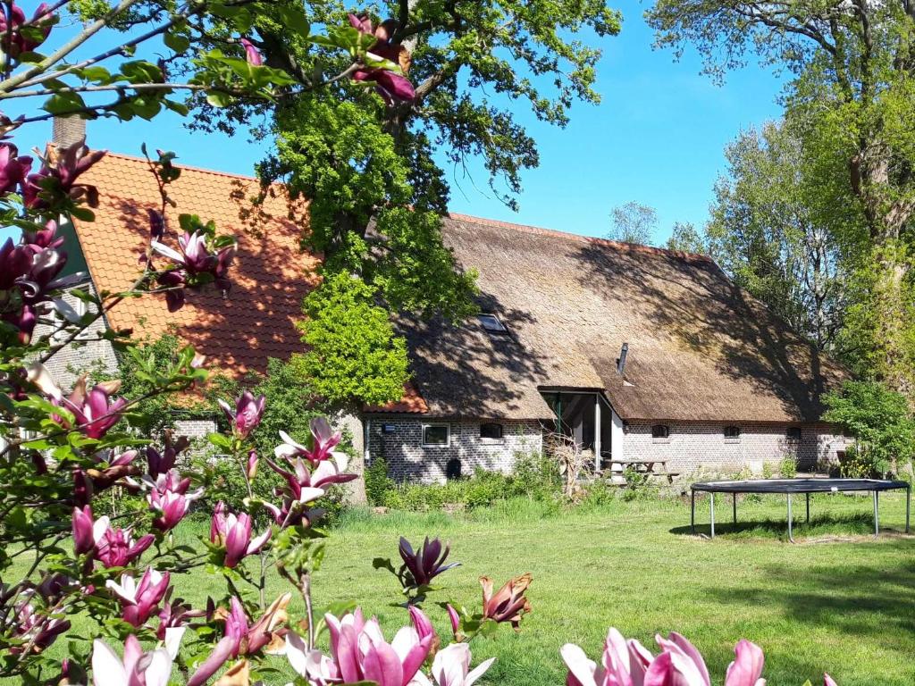 uma casa velha com uma mesa em frente em Sfeervolle vakantiewoning midden in het Drents-Friese Wold em Wateren