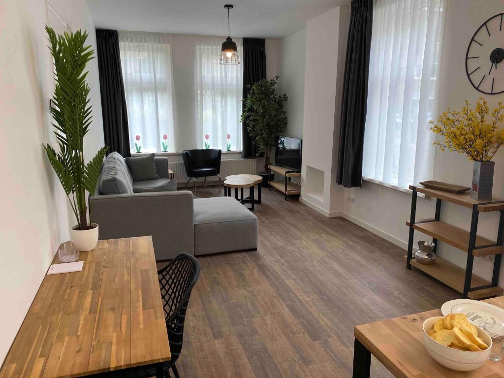 ein Wohnzimmer mit einem Sofa und einem Tisch in der Unterkunft HaagsHuisje- eigen appartement, dichtbij alles, stijlvol in Voorburg