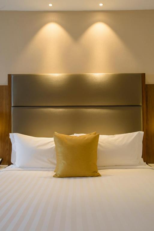 a bed with a large headboard and white pillows at Crowne Plaza Nairobi Airport by IHG in Nairobi